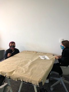 Students making cuts in cloth for a no sew blanket